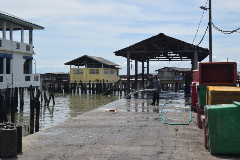 龟咯当地另一经济支柱——海产养殖业在运作，渔民码头处有工人在进行清洗工作。