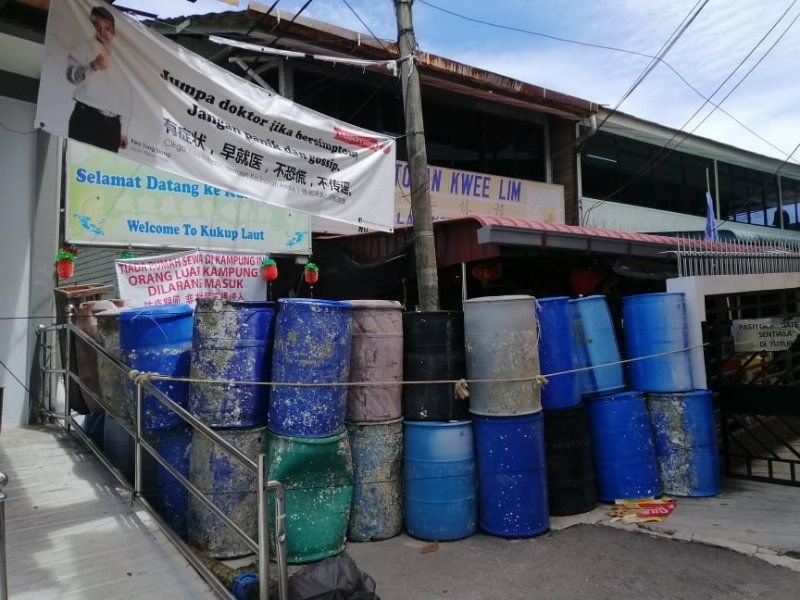 因担心疫情扩散，龟咯港脚村民在村的入口处使用大型塑料桶高高的叠起来，形成一道“水桶墙”防线，禁止外人进入。