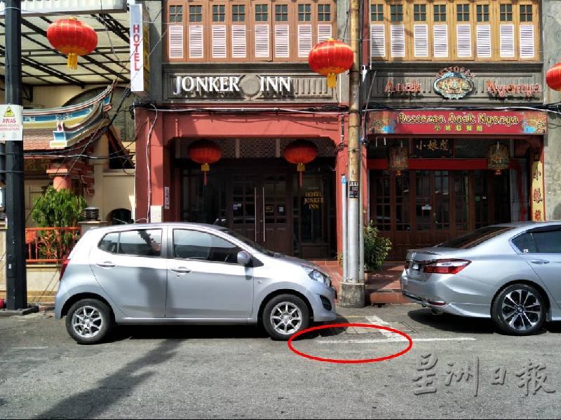 在鸡场街,用黑漆盖掉的停车格子白线再次浮出,车主泊车被开罚单。