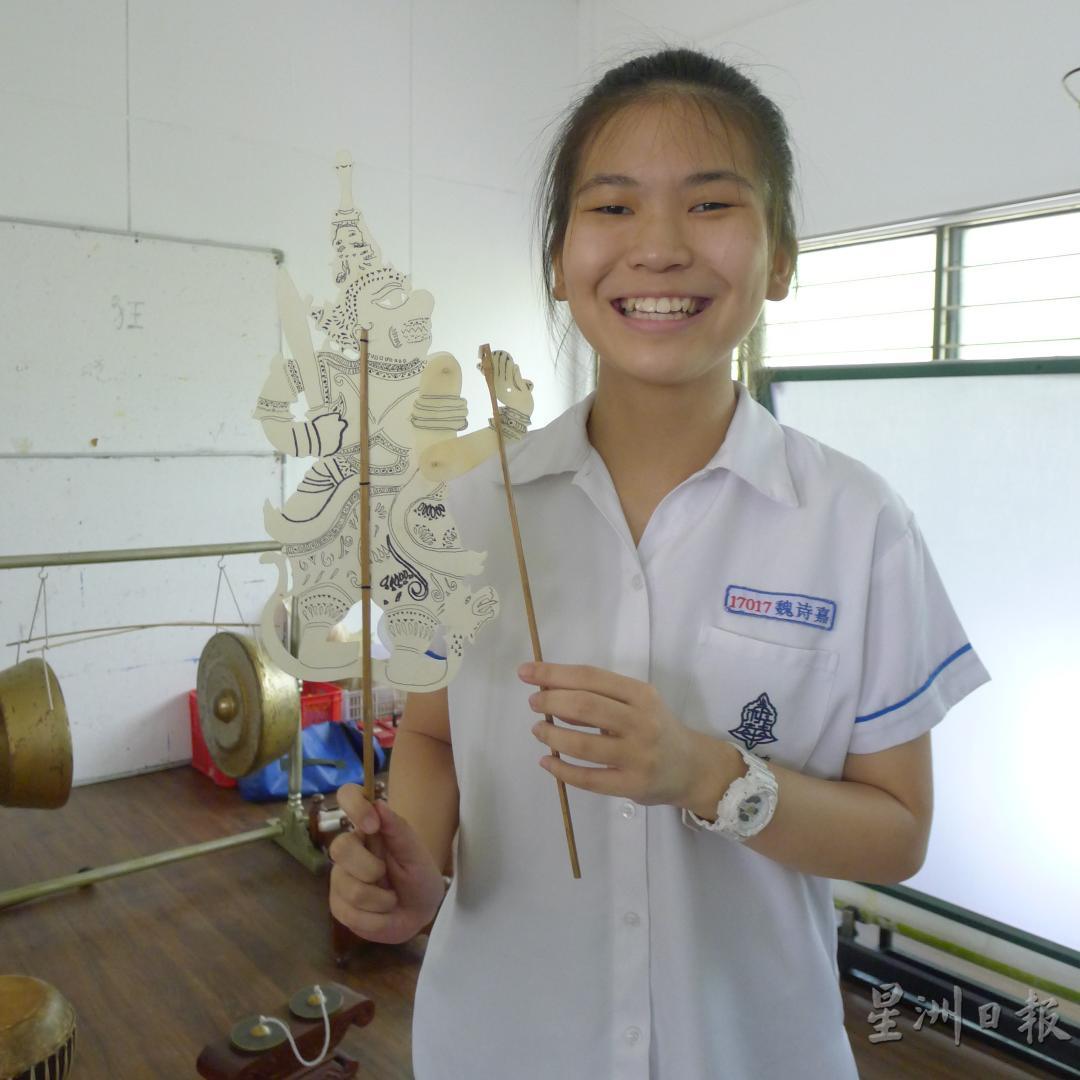 魏诗嘉同学开心地展示自己亲手制作的皮影戏偶。