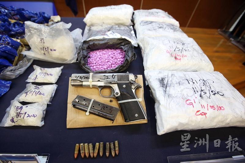 警方展示起获的粉红色摇头丸、一把自动手枪和子弹，及摇头丸粉。