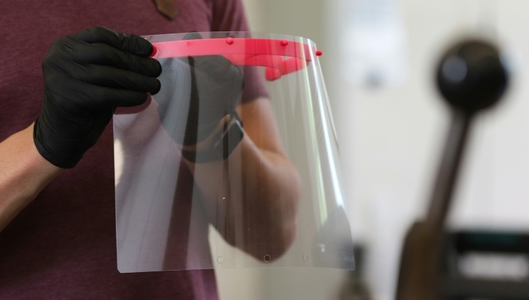 3D printers fabricate the red piece that holds a sheet of transparent plastic. AFP