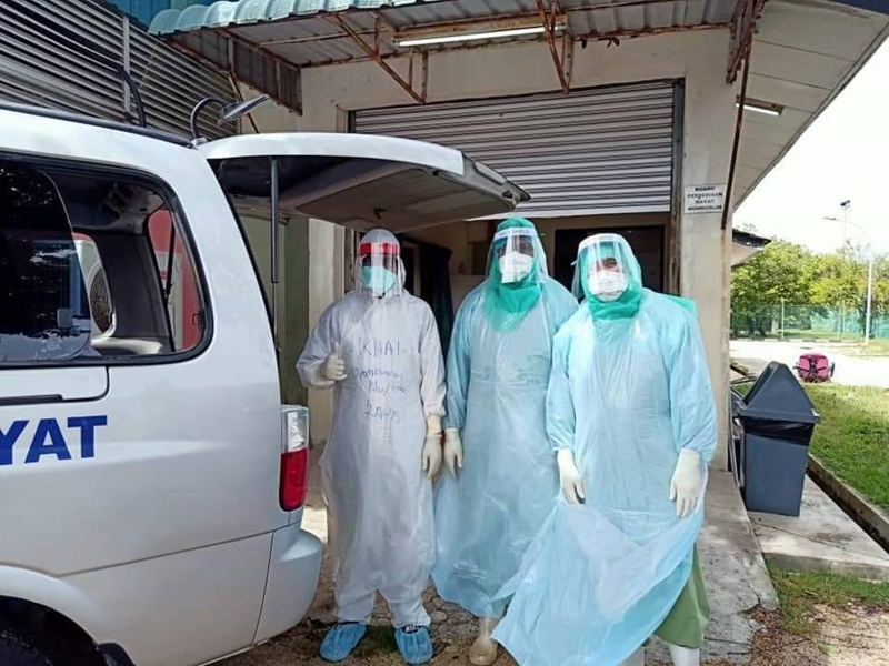 穿戴个人防护设备的工作人员来到关丹中央医院太平间，准备为冠病确诊死者进行殓葬。