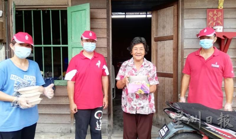 吴锡标（右）与团队赠送蛋糕及素食给乐龄妇女刘来荫（右二），令她乐开了怀。