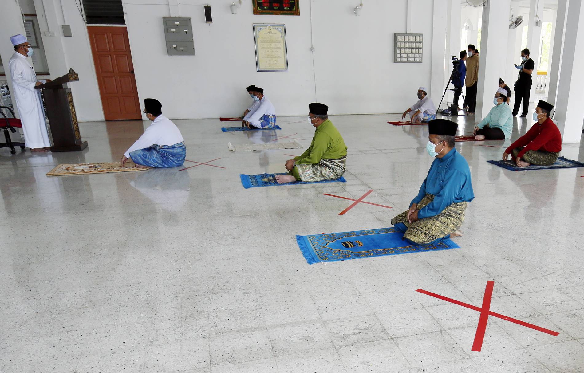 阿斯里（左）在周五祈祷开始前，向清真寺职员及理事发言。