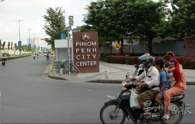 一家柬埔寨人在摩哆上骑行，经过金边市中心。2016年，柬埔寨脱离世界银行的“低收入国家”行列，晋升为“中低收入国家”。（摄影/冯依健）