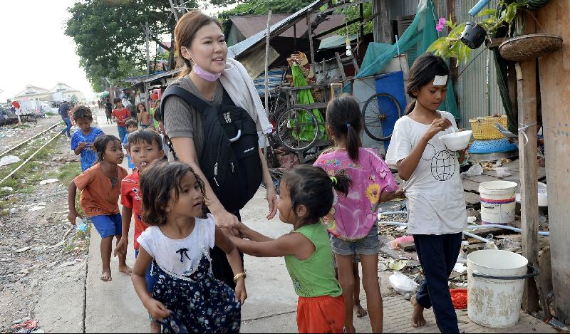 Cheryl Loo surrounded by slum children yearning for her loving care. SIN CHEW DAILY