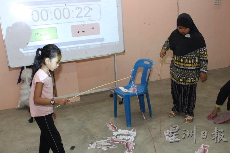 穆益斯自制教材，让学生在课堂上与其他同学一边模拟钓鱼，一边用华语交谈。