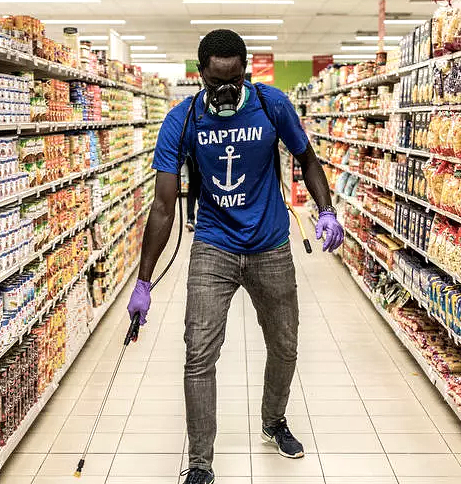 A man disinfects an empty supermarket in Dakar. AFP