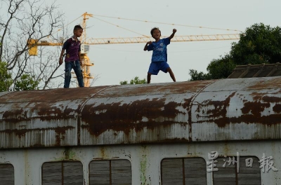 贫民窟的孩子爬上废弃的火车頂嬉闹。（摄影/冯依健）