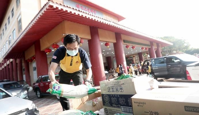 A Fo Guang Shan volunteer loads boxes of relief items onto the van. SIN CHEW DAILY A Fo Guang Shan volunteer loads boxes of relief items onto the van. SIN CHEW DAILY