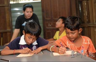学习中心里，高棉语老师（站立者）正在教导学生写字。（摄影/冯依健）