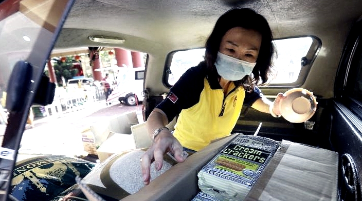 A Fo Guang Shan volunteer loads boxes of relief goods onto the van to be delivered to welfare homes. SIN CHEW DAILY A Fo Guang Shan volunteer loads boxes of relief goods onto the van to be delivered to welfare homes. SIN CHEW DAILY
