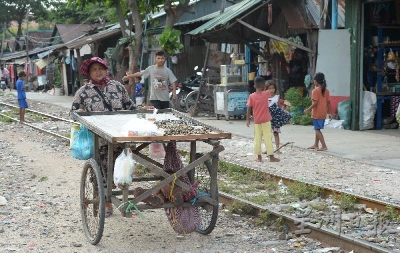 许多来自贫民窟的住户，推着手推车，以兜售河螺为生。（摄影/冯依健）