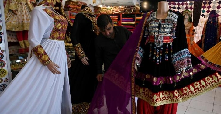 A shopkeeper displays a dress on a mannequin as he waits for customers. AFP
