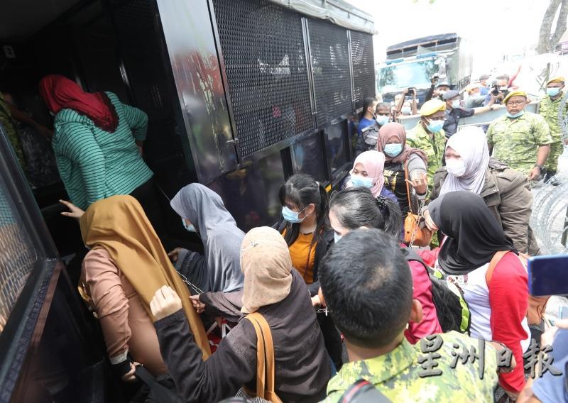 约200名非法外劳被押送上移民局的罗里送往扣留中心。
