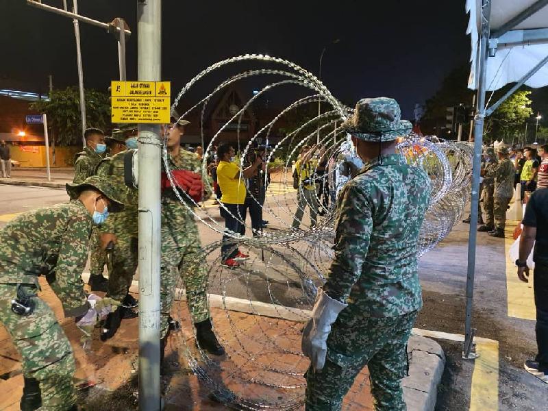 图为军警人员,忙着拆除早前围筑的铁蒺藜网。