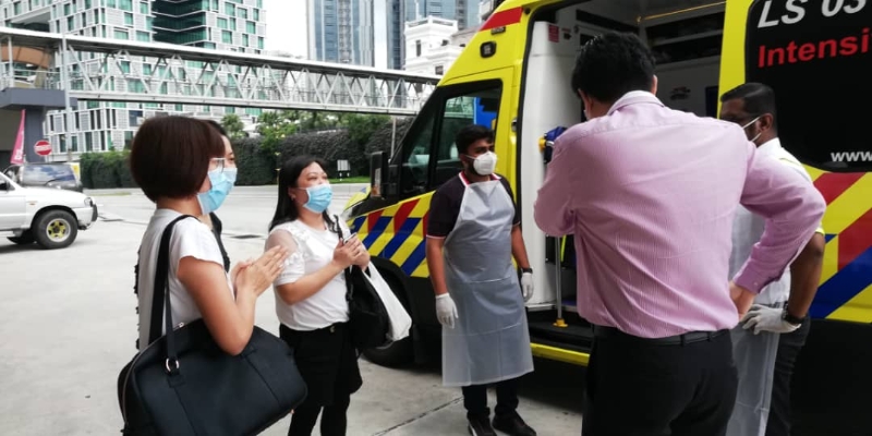 救护车从新加坡载送唐丽娟往新山，再由另一辆救护车接力载送她回到峇株巴辖，曾茄恩（前排右一）也到场协助。