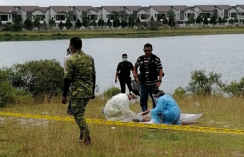 警方和医护人员在安达拉加比湖畔，将跳湖自杀的嫌犯打捞上岸。