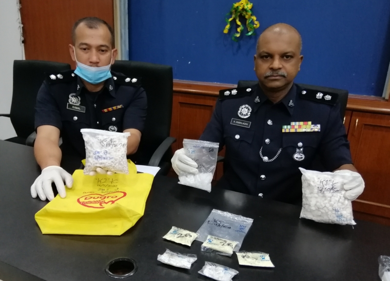 安巴拉甘（右起）在警官卡玛尔的陪同下，发布两宗毒品案。