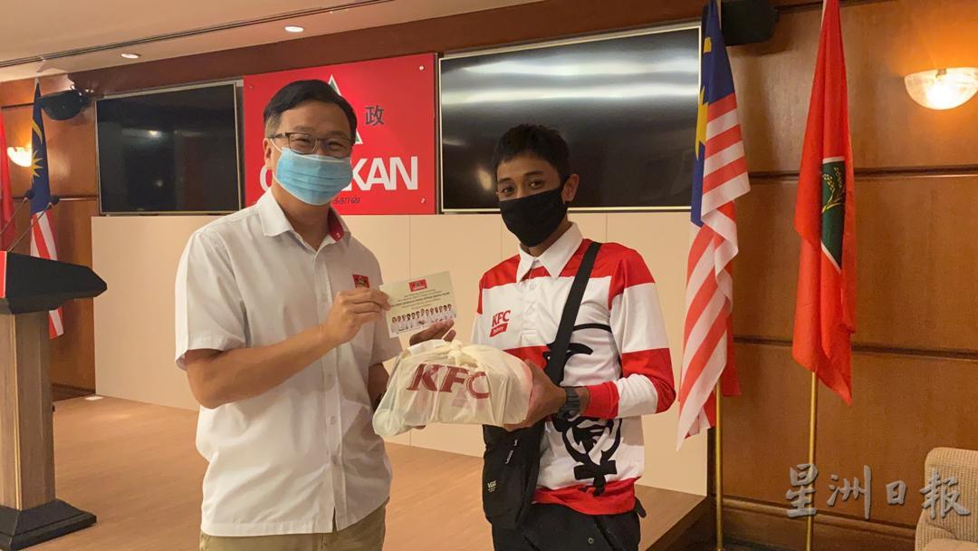 刘华才（左）在“关爱前线送餐员”运动中，赠送餐饮和感谢卡给送餐员。