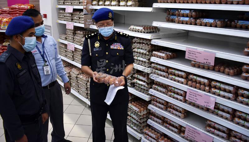 陈进松（右）检查诗不朗再也特宜购霸级市场的鸡蛋售价。