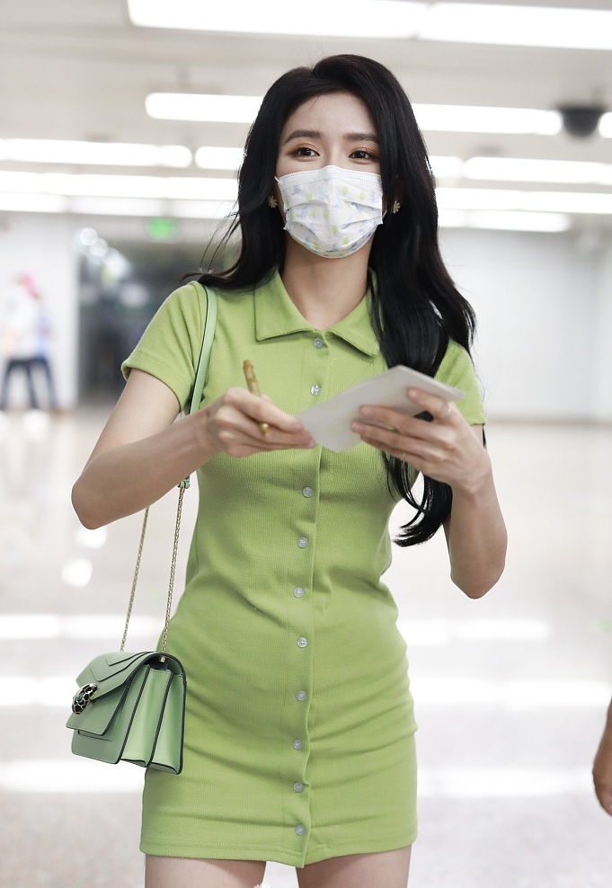 蔡卓宜戴着口罩，身穿绿色长版T恤现身机场，大方露出纤细美腿。