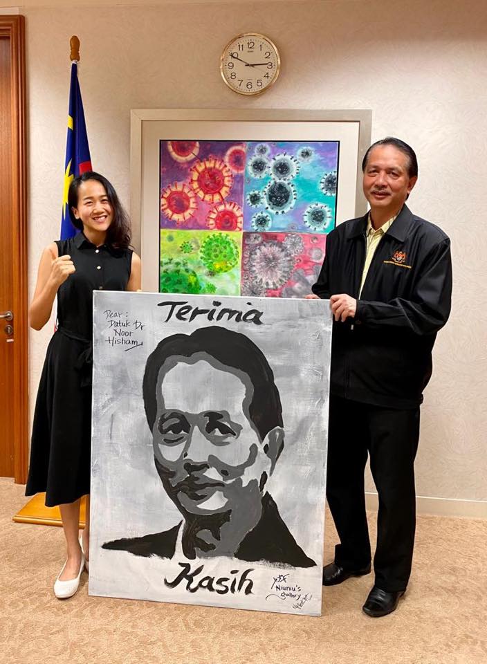 黄雪媛（左）送上了亲手绘画的肖像画给诺希山，感谢他在抗疫方面作出的贡献和牺牲。
