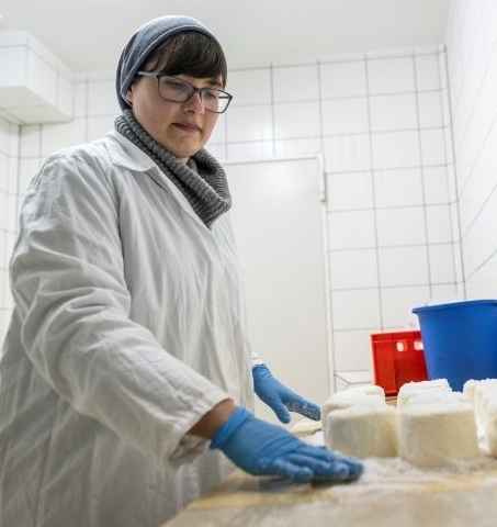 Izabela Ciesielska, a psychologist by training, covers goat cheese with salt on the 'Nad Arem' farm. AFP
