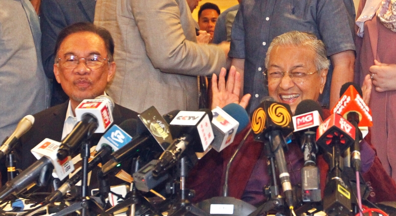 马哈迪（右）在当晚的记者会上表示大家当时已达成共识，将交棒日期全权交给他，当时的他还开心地笑得见牙不见眼。