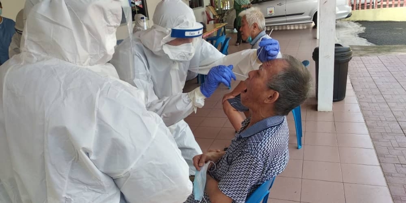 卫生部医护人员正为养老院的长者进行鼻喉拭子测试。