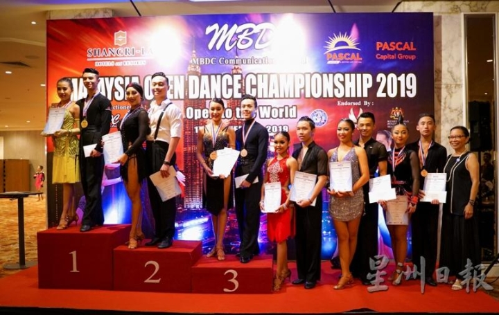魏妤静（左起）与舞伴萧伟乐在去年的马来西亚国际标准舞公开赛中，赢得了拉丁舞业余组冠军。（受访者提供）