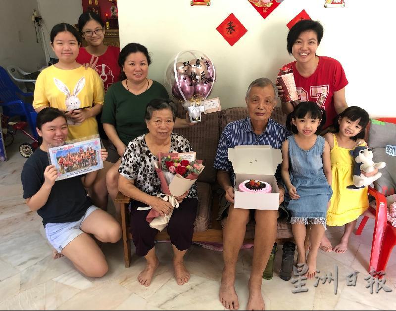 马金平（前右三）和郑苏妹（前左二）在家人的陪同下收到来自新加坡儿子的爱的礼包后，感动又开心。