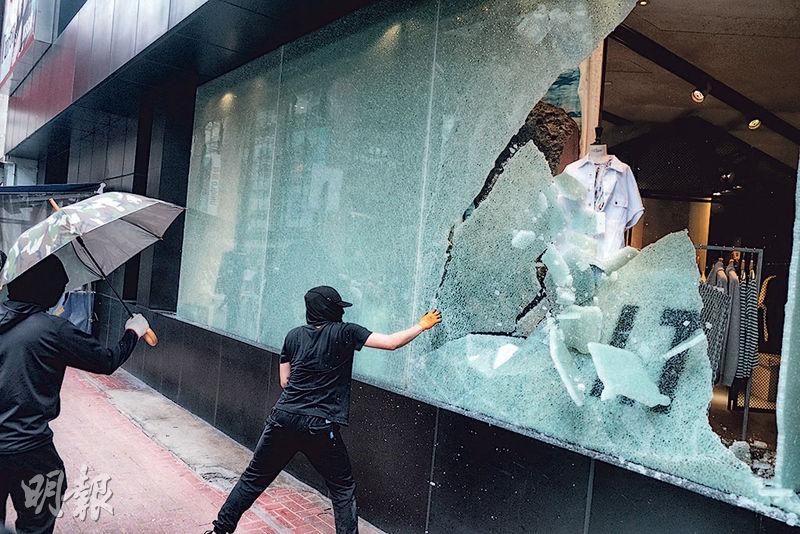 位於希慎道的“I.T”时装店铺橱窗被击破，示威者将橱窗内物品搬出路面，警方其後赶至驱散。（冯凯键摄）