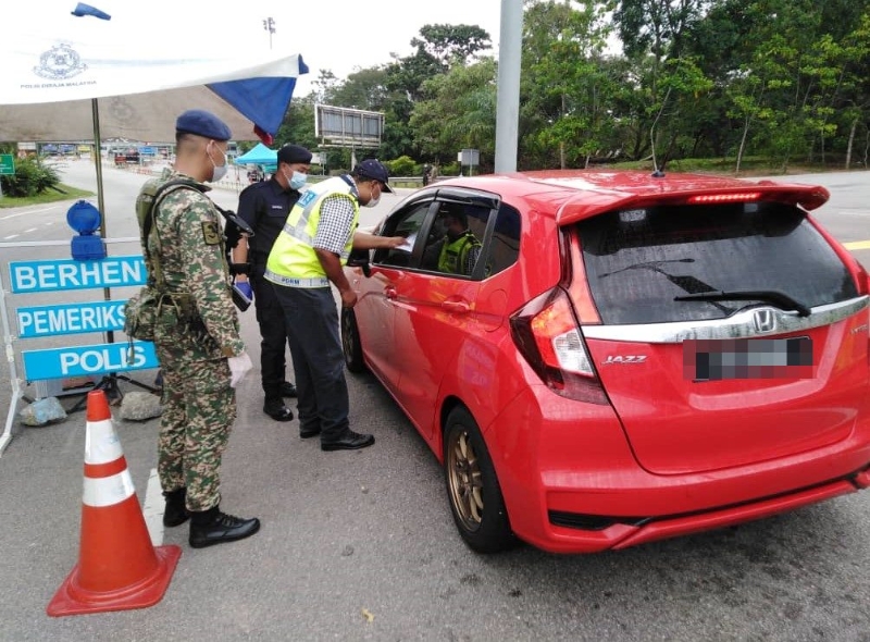 
军警人员位于各路障询问车主外出的理由及目的地。