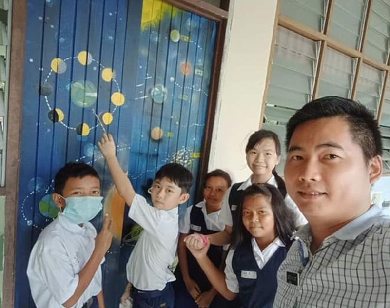 陈健雄让学生们在墙壁上画太阳系，以生动有趣的方式教学。