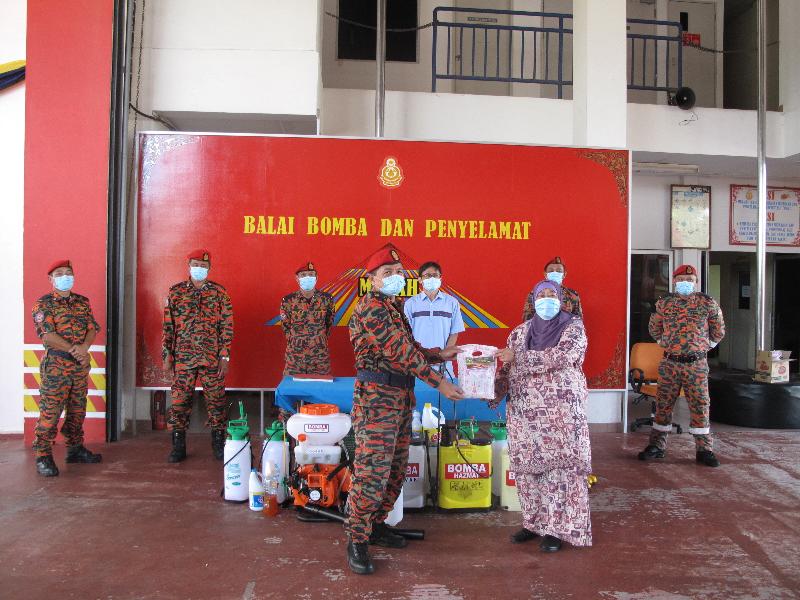 
沐胶省长哈查汉蒂雅（前右）赠送开斋节糕点予沐胶消防与拯救局局长阿兹曼。