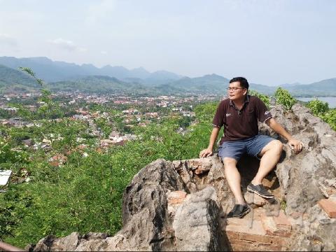普西山（Phou Si Mountain）高达350呎，站在最高处可以鸟瞰整个龙坡邦。陈炳瑞2006年登上这里，就深深爱上龙坡邦的平静生活。当时恰好创业顺利，不知不觉在当地住了13年。