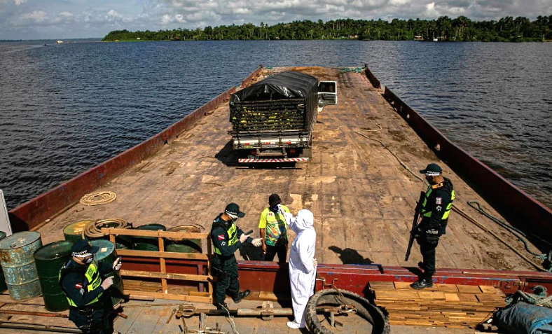 A government medical worker checks the temperature of a man on a pier in Melgaco bay in Brazil's Para state. AFP