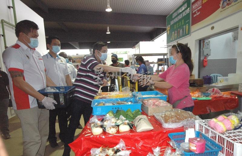 张聒翔（左二起）和芙蓉国会议员陆兆福派送茶叶蛋予贩商，并向他们了解目前的处境。