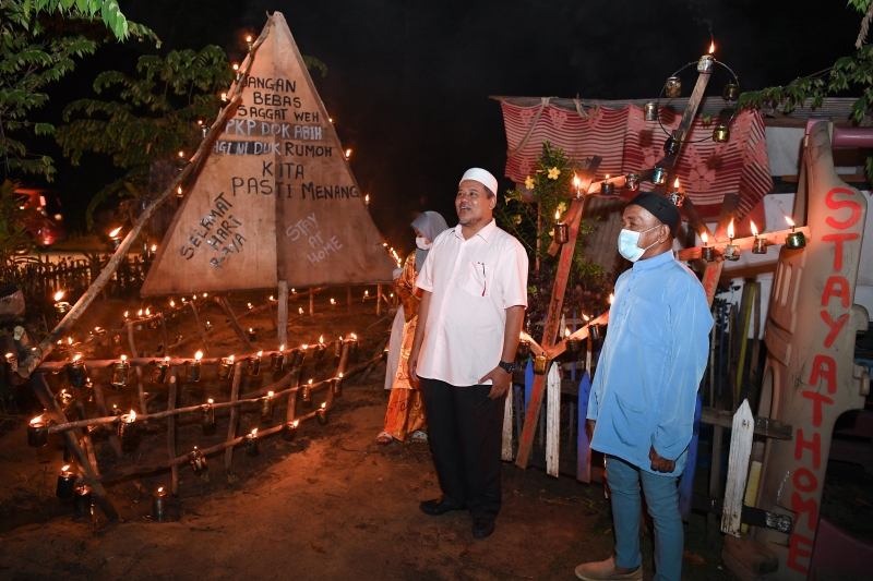 阿里菲德拉曼（右二）参观村民们精心设计的油灯装饰。