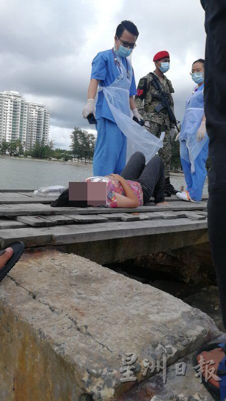 企图跳海自杀的女子被拉上防浪堤。