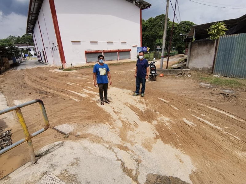 李茂光（左）和林胜鸿视察布满黄泥的道路，要求玻璃口志愿消防队协助清洗。