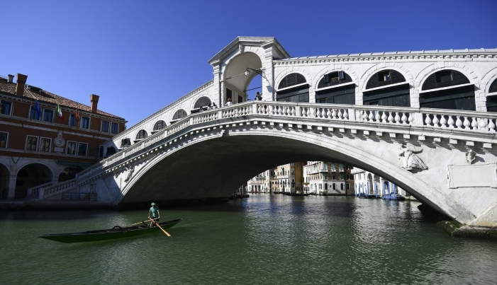 A gondola rides under the Rialto bridge. AFP