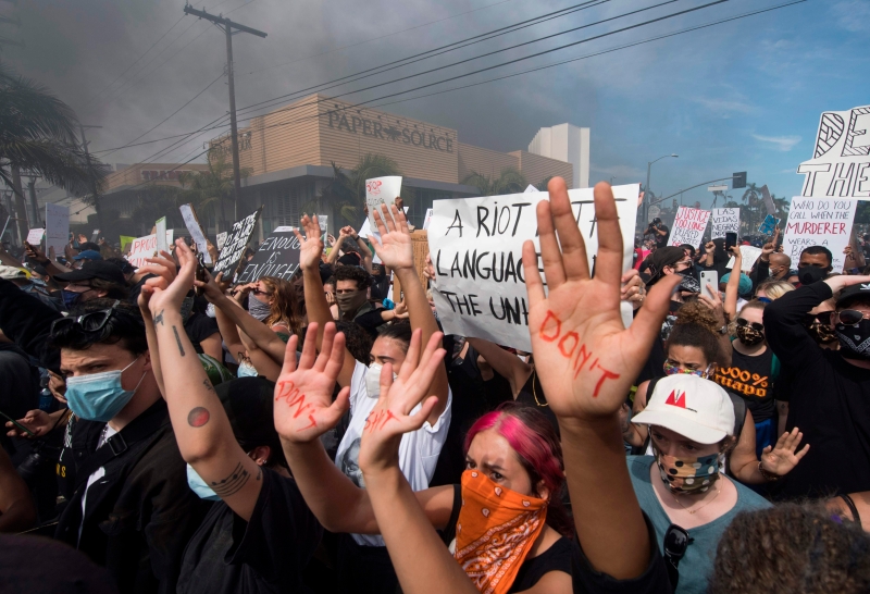 在洛杉矶费尔法克斯区，示威群众在与警方对峙时举手，呼吁警方停止暴力对待公民。（图：法新社）