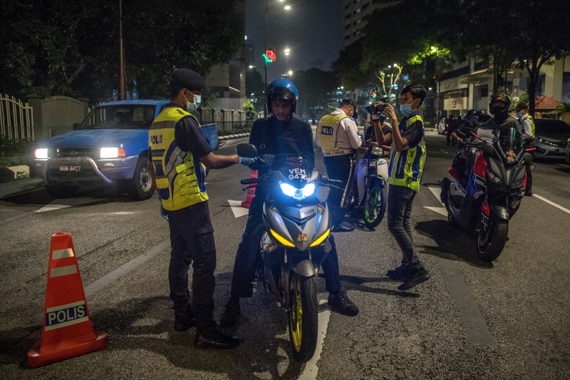警方在拉惹劳勿路设路障，检查来往的车辆及摩哆车是否违反交通规则。