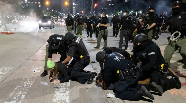 Detroit police arrest a protestor during marches. AFP