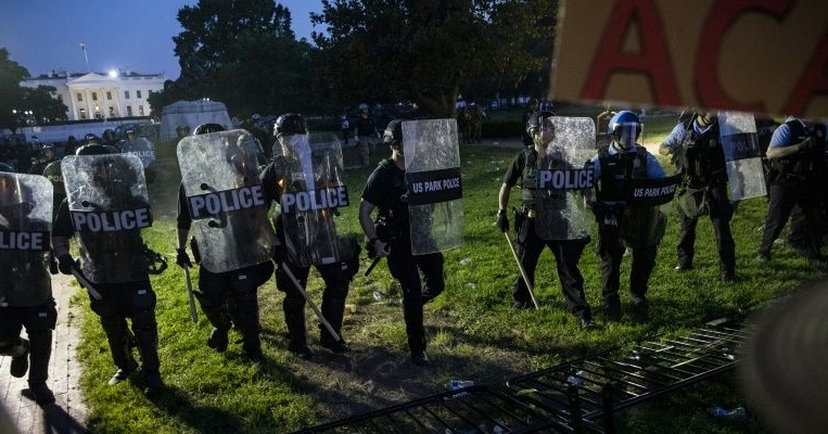 Police move toward demonstrators gathered outside the White House. AFP