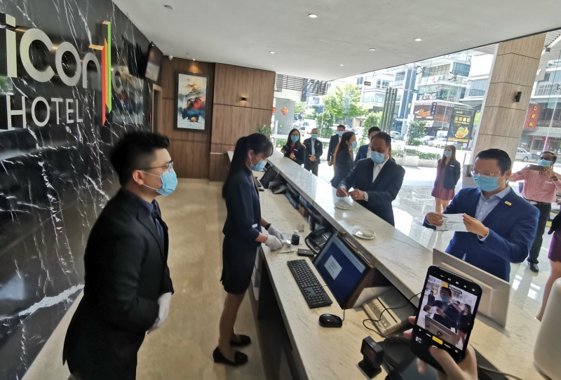 杨顺兴（右一）在宾客接待处了解标致酒店的标准作业程序。