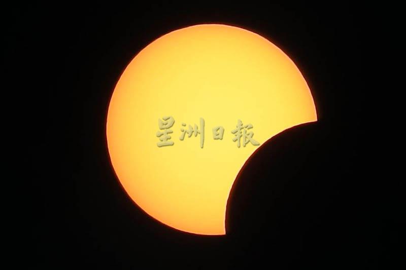 在借助滤镜拍摄下，日食产生太阳“被咬了一口”的错觉。